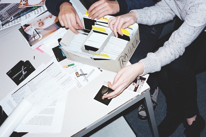 Two people searching through archival box of polaroids from past transmediale festivals.